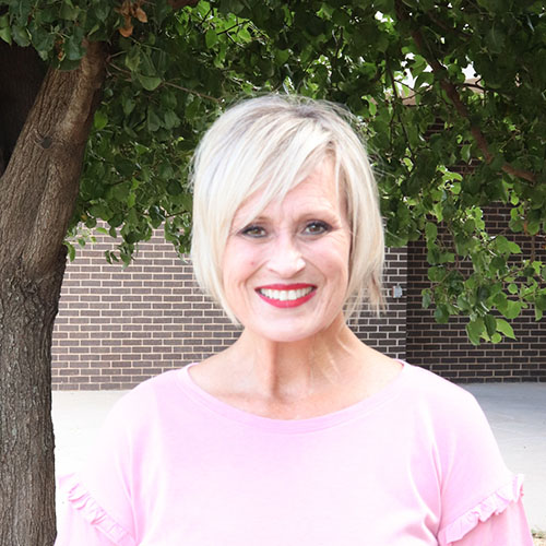 Woman with short blonde hair and pink shirt