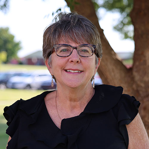 Woman with short dark hair and glasses