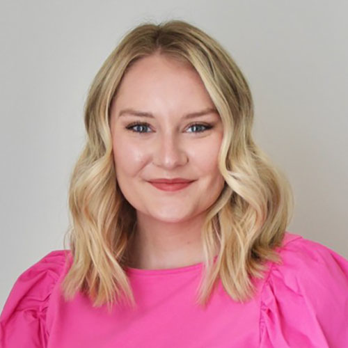 Woman with long blonde hair wearing a pink shirt