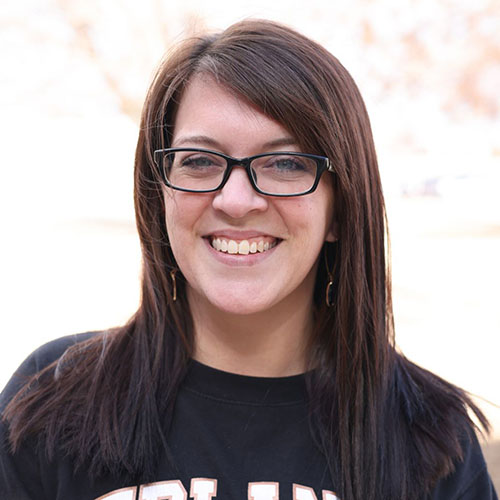 Woman with long dark hair and glasses