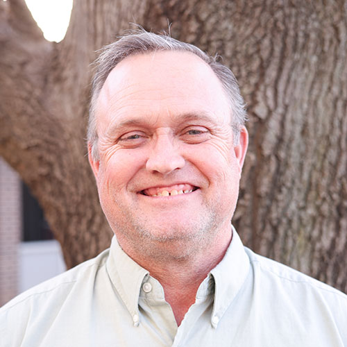 Man with short hair wearing a green shirt