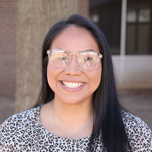 Woman with long dark hair and glasses