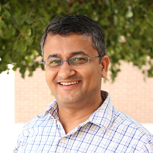 Man with dark hair and glasses