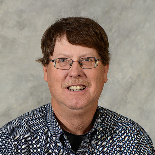 Man with brown hair and glasses