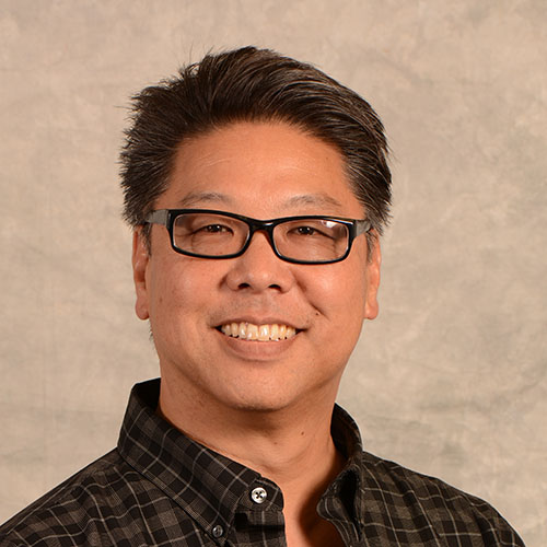 Man with short dark hair and glasses