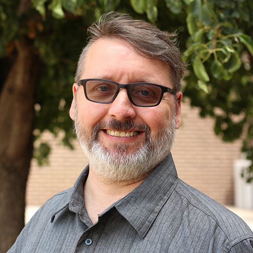 Man with a gray beard and glasses