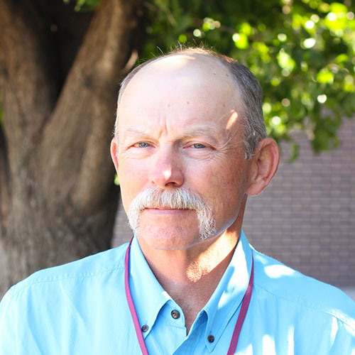 Man with short gray hair and a moustache