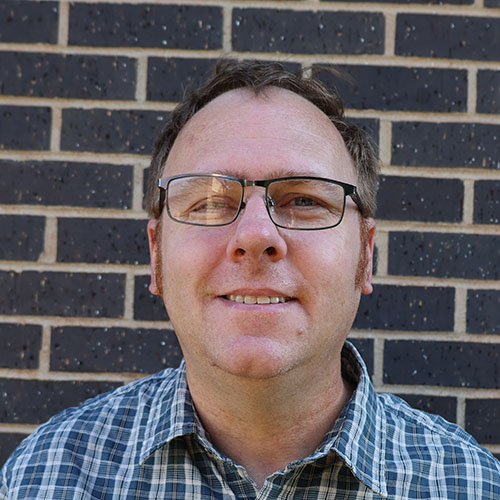 Man with short brown hair and glasses