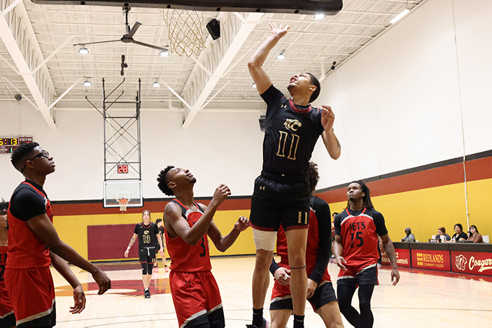 A player jumps for a ball, surrounded by opponents